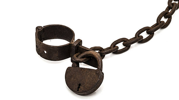 Rusty old shackles with padlock Rusty old shackles with padlock used for locking up prisoners or slaves between 1600 and 1800. medieval restraints stock pictures, royalty-free photos & images