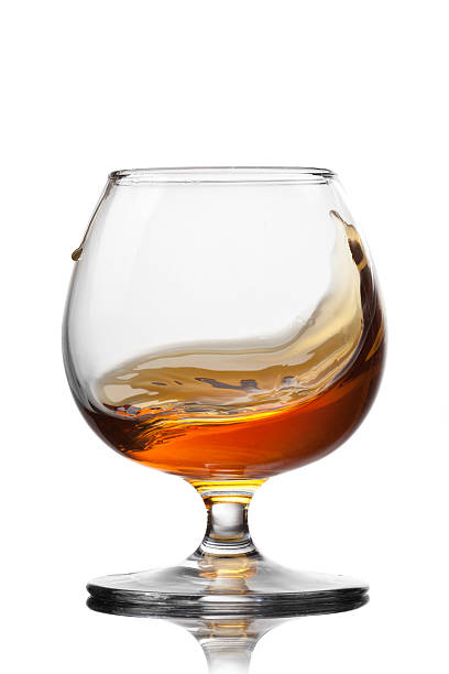 istock Splash of cognac in glass isolated on white background 480468045