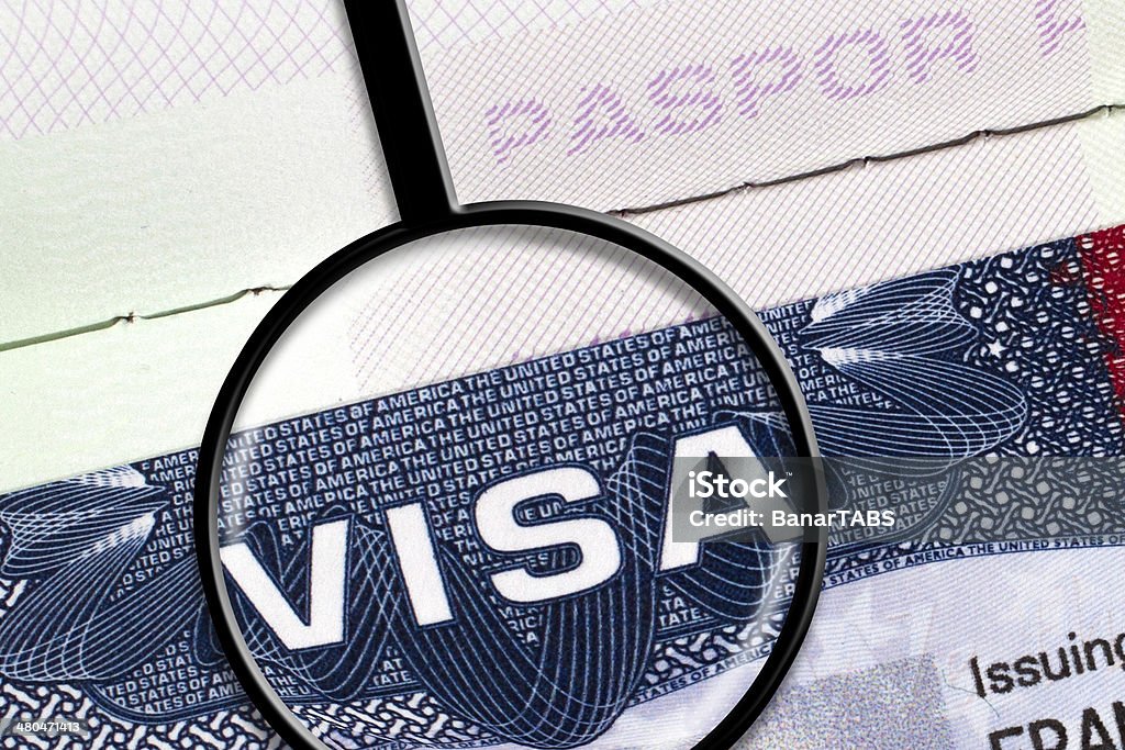 US Visa Detail from a USA visa document with magnifying glass. Emigration and Immigration Stock Photo
