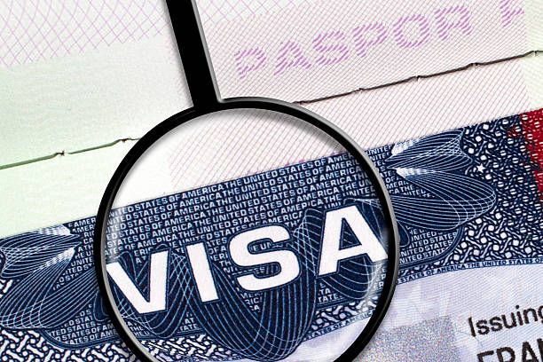 US Visa Detail from a USA visa document with magnifying glass. passport stamp stock pictures, royalty-free photos & images