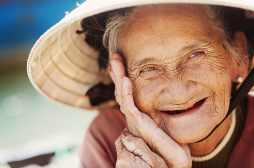 Close up face of beautiful smiling woman with wrinkles. Elderly senior.