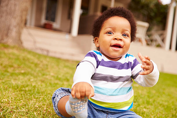 istock Toddler sitting on the grass in a garden 480473676