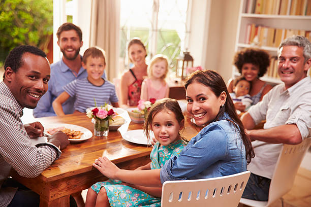 istock Family and friends sitting at  dining table, looking at camera 480473696