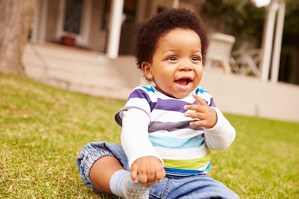 istock Toddler sitting on the grass in a garden 480477152