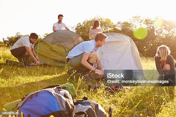 Group Of Young Friends Pitching Tents On Camping Holiday Stock Photo - Download Image Now