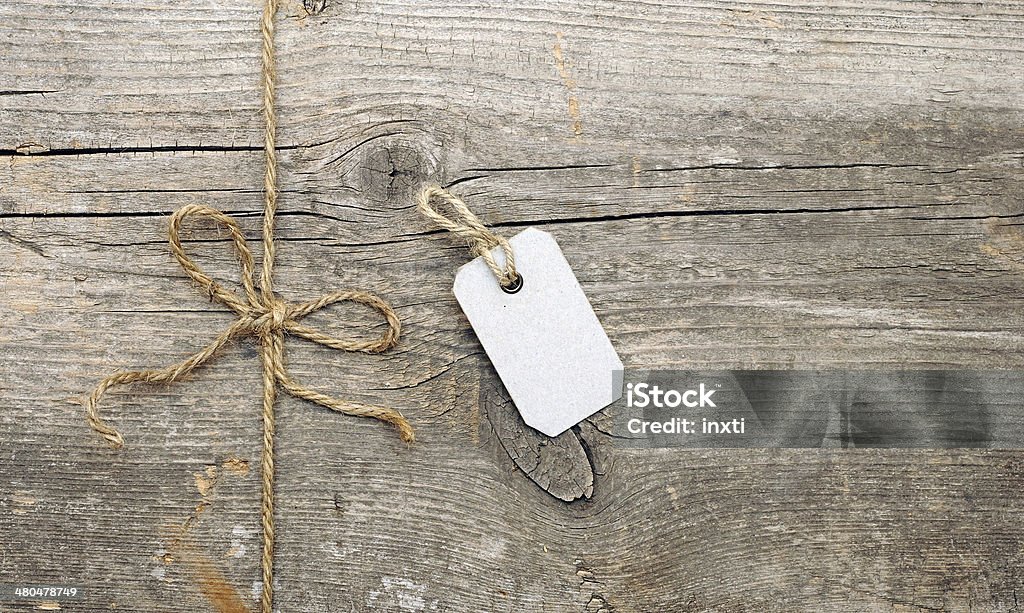 String tied in a bow and address label attached String tied in a bow and address label attached. With copy space Backgrounds Stock Photo