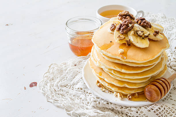 istock Pancakes with banana, nuts, honey, white wood background 480480300