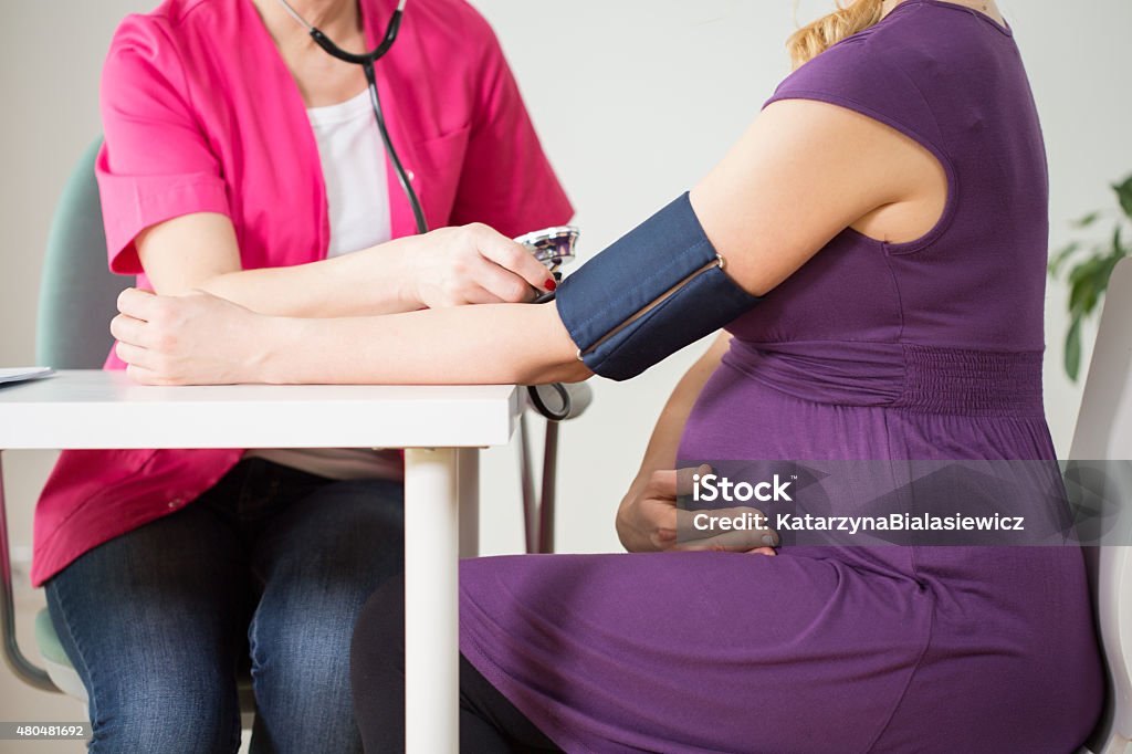 Doctor measuring pressure Close-up of doctor measuring pressure of pregnant woman Pregnant Stock Photo
