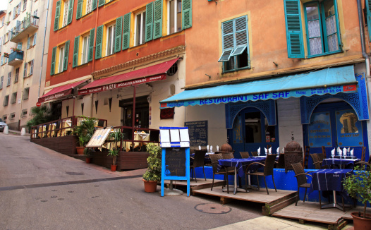 Nice, France - May 14, 2013: Multicolored houses and oriental ethnic restaurants in the Old town Nice - the largest resort and tourist town on the French Riviera, Cote d'Azur, France at May 14, 2013.