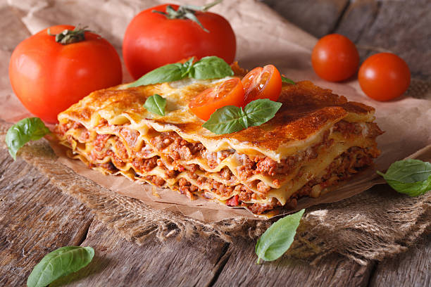 istock Italian lasagna with basil close-up on paper, horizontal rustic 480484256