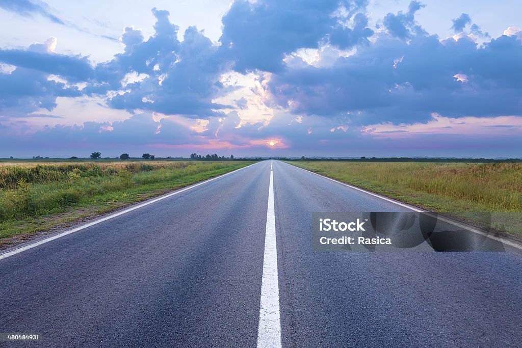 Estrada vazia na planície, ao amanhecer - Foto de stock de Azul royalty-free