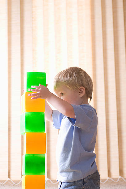 istock Boy Building Colorful Bricks At Home 480485245