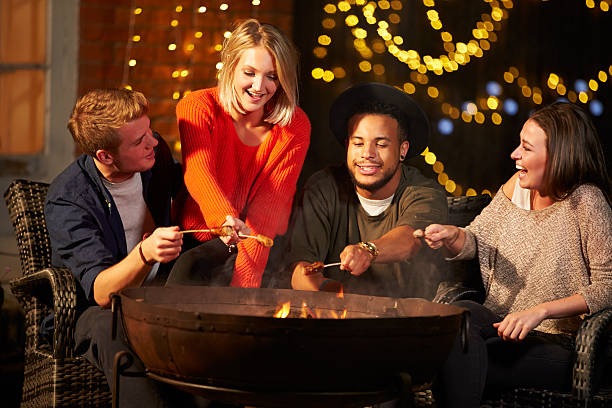 istock Group Of Friends Cooking Sausages By Firepit 480486450