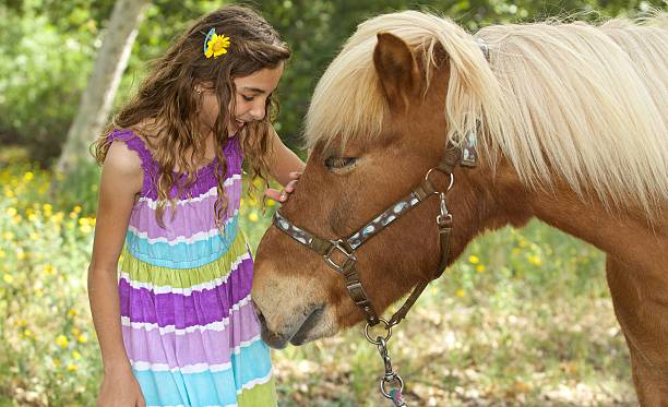 istock Pretty Girl Giving her Pony a pat on his Muzzle 480488706