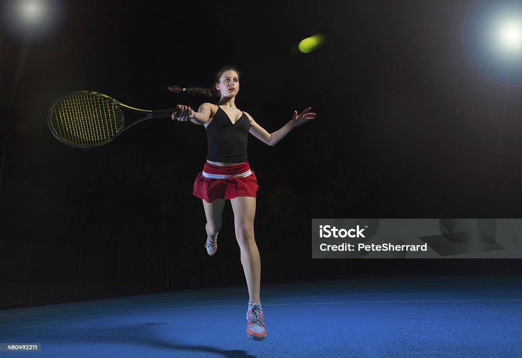 Female tennis player A female tennis player playing a forehand shot, leaping into the air.A female tennis player playing a forehand shot, leaping into the air. Activity Stock Photo