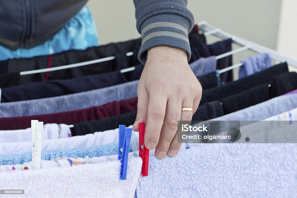 Young man drying clothes after laundry Man hands hanging wet clothes on clothes-line for drying Adult Stock Photo