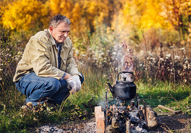 człowiek boils sooty czajnik na ogień - kociołek herbaty zdjęcia i obrazy z banku zdjęć