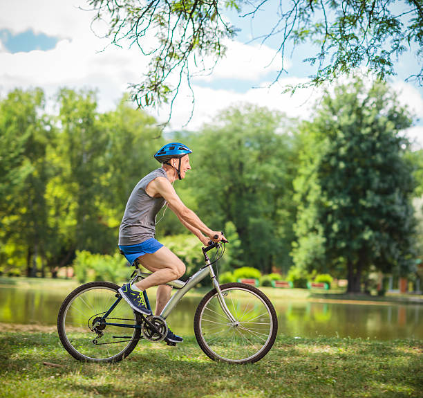 istock Joyful senior biker riding a bicycle in a park 480495884