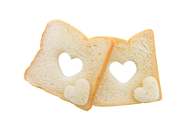 Heart shaped hole in a slice of bread isolated