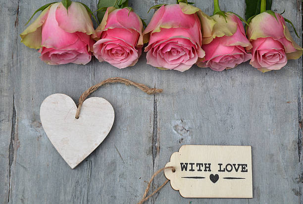 istock pink roses on old grey wood and empty heart  label 480496272