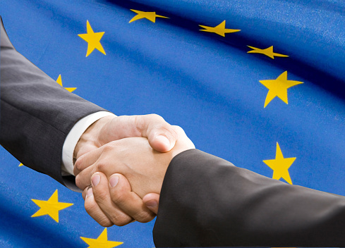 Handshake over EU flag. Partnership and  politics concept.