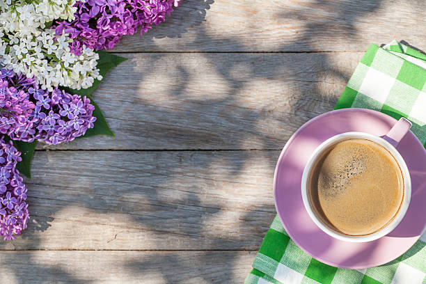 istock Coffee cup and colorful lilac flowers on garden table 480500204