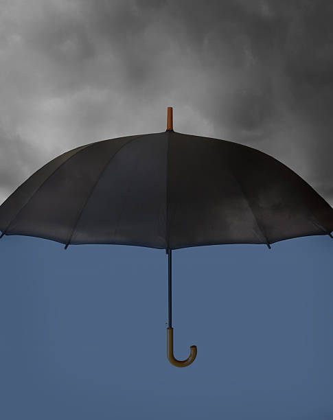 istock Umbrella with heavy clouds above and clear blue under 480500237