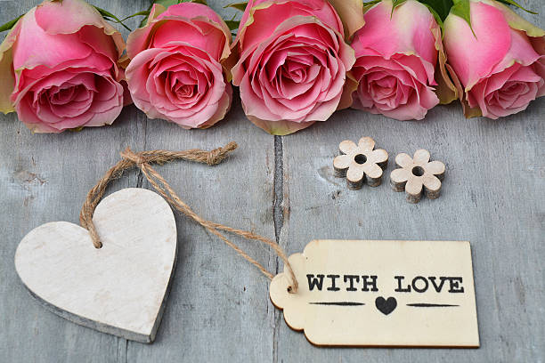 istock pink roses on old grey wood and empty heart  label 480500586