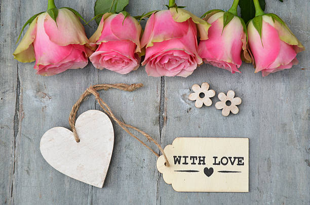 istock pink roses on old grey wood and empty heart  label 480500654