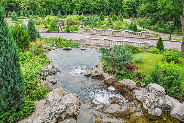 istock Landscape Park. Waterfall, bridge, rocks. Beautiful ornamental plants and trees 480504450