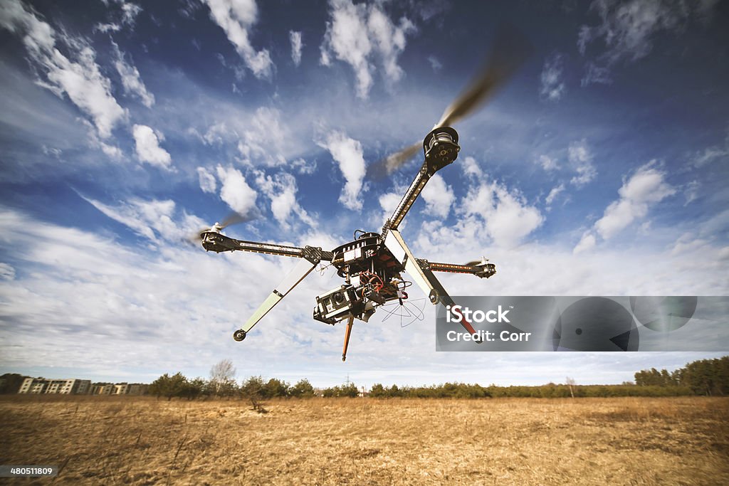 Quadrocopter drone flying in the sky Flying drone is filming video in the blue sky Drone Stock Photo