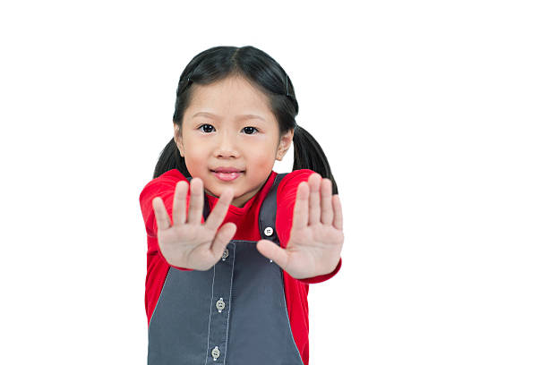 Little girl giving hand stop sign.