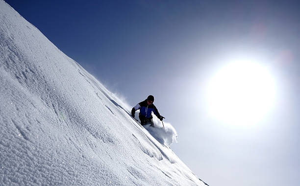 Skiing - Backcountry skiing - Extreme Skiing Extreme skier backcountry in deep snow against the sun extreme skiing stock pictures, royalty-free photos & images