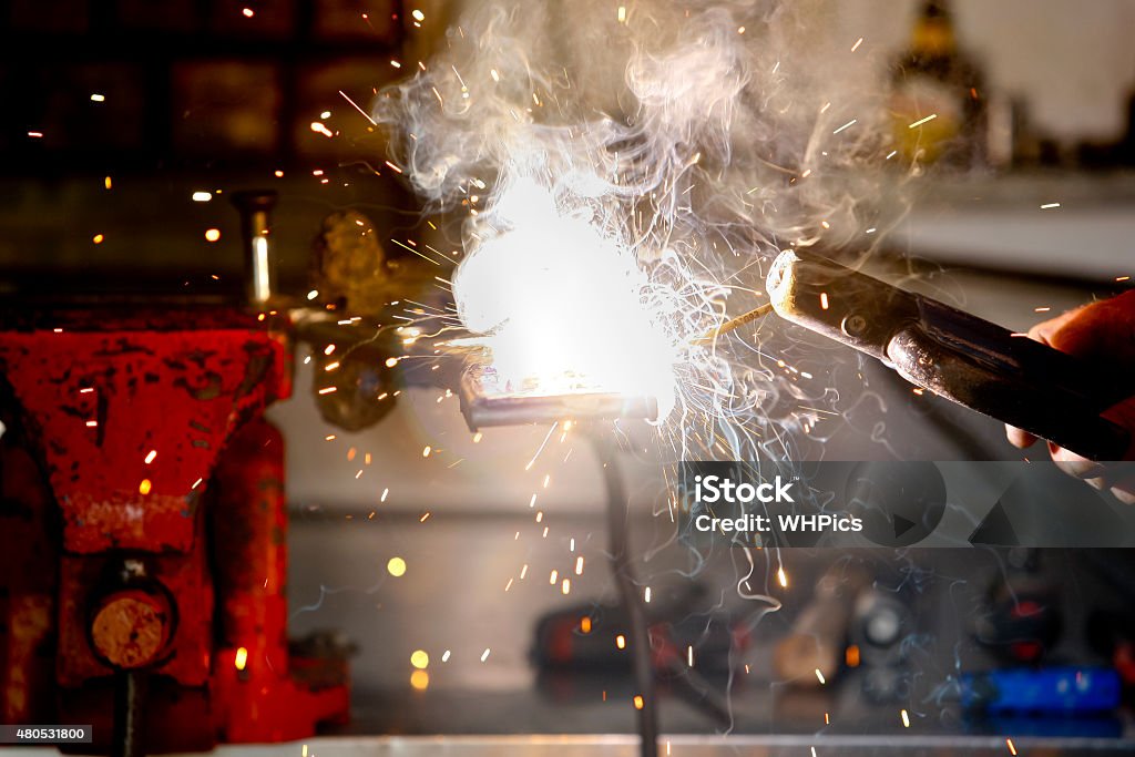 Worker in action with no protection gloves Stick welding worker in action with no protection gloves 2015 Stock Photo