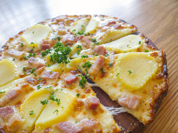 Pizza potato and ham on a wooden board