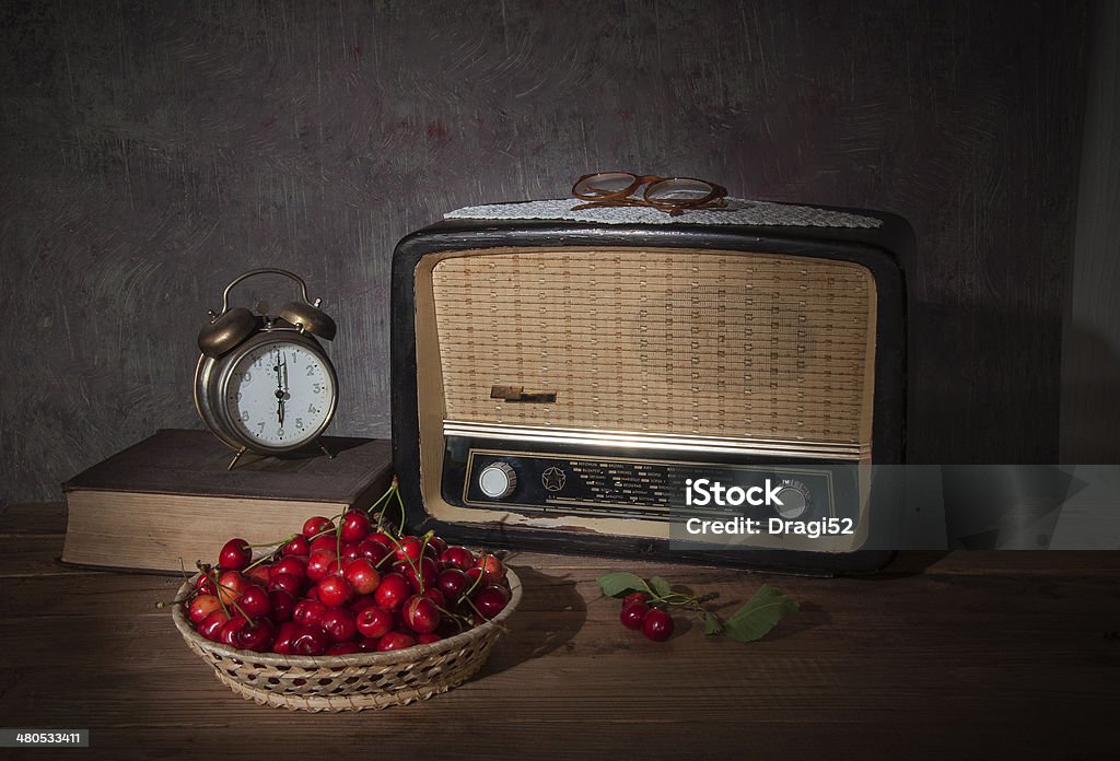 The old radio and fresh cherries The old radio and fresh cherries on wooden table Alarm Clock Stock Photo