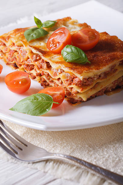 istock lasagna with basil and tomatoes  on a white plate. vertical 480537038
