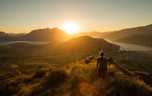 Woman silhouette at sunset on the mountain. New Zealand