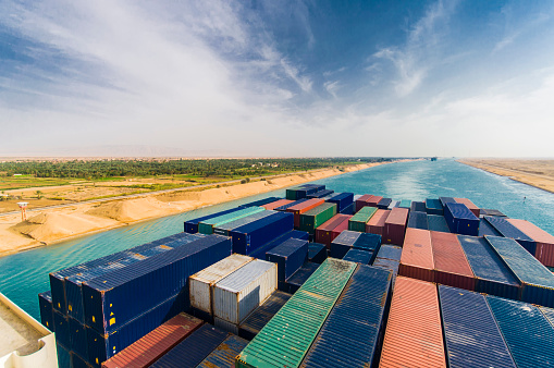 Horizontal photo of the stern of container ship passing through Suez Canal also known as Malrboro Canal.