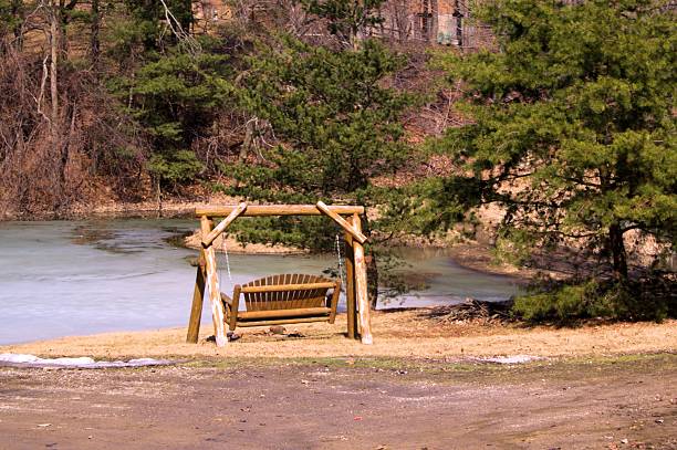 istock Wooden swing by frozen pond. 480543733