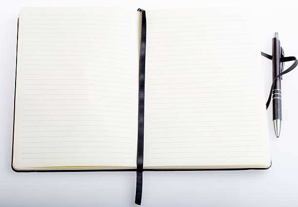istock Open Book on a Table with a black metal pen 480546164