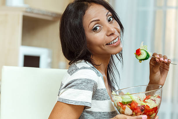 istock Beautiful woman eating fresh salad in modern kitchen 480547138