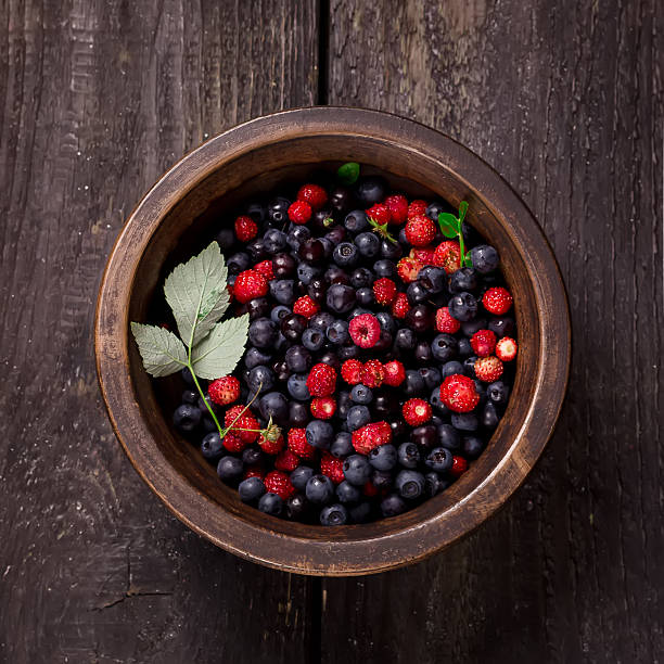 istock Bowl with wild berries on dark wooden background. Style rustic. 480547248