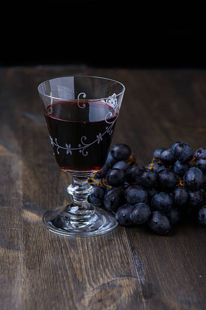 istock Red wine with grapes the side on wood table 480547453