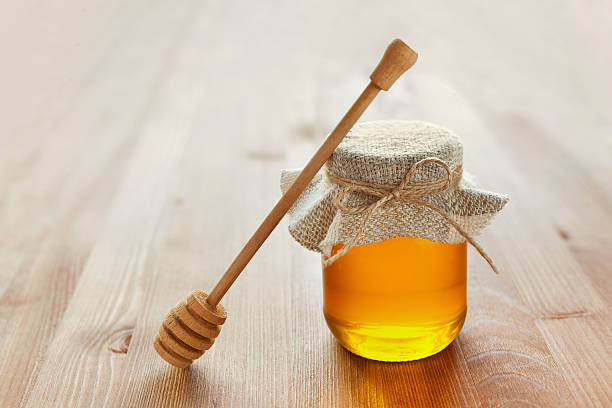 istock honey in jar with twine, honey dipper, lemon and ginger 480549138