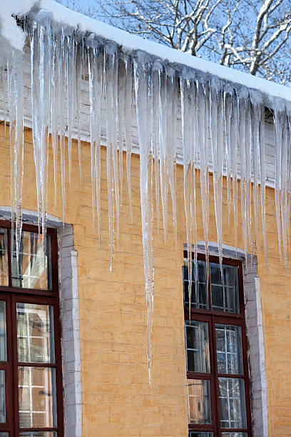 istock Snow-covered roof with big icicles in winter day 480549672