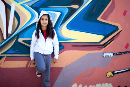 Girl standing against graffiti wall