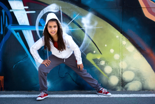 Young woman standing in front of the graffiti on the wall