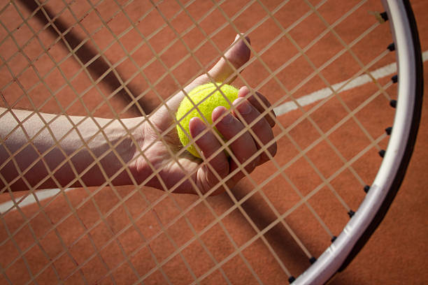 mão segurando a raquete de cordas uma bola de tênis - racket string - fotografias e filmes do acervo