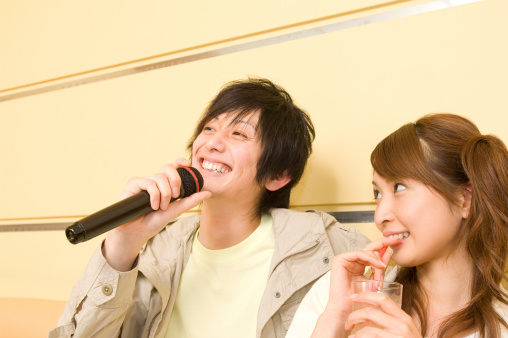 Man singing at karaoke and woman gazing at him